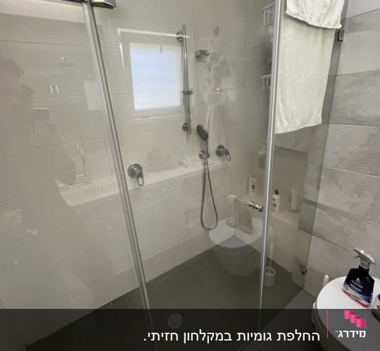 מקלחת עם ראש גשם, מגבת תלויה, מוצרי טיפוח